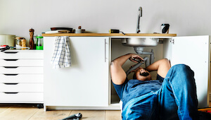 plumber man fixing kitchen sink - DomiDocs